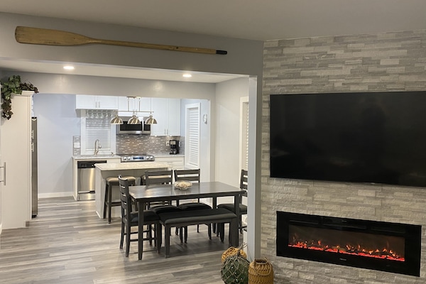 Great room with Samsung smart TV, electric fireplace, dining and kitchen.