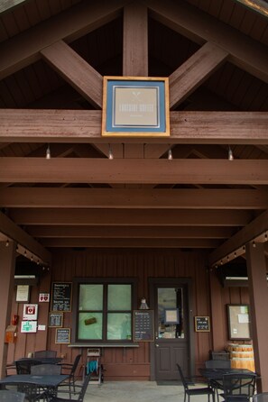 A wooden building with a sign reading "Lakeside Cafe." There are tables and chairs outside, and a menu board is visible. - Welcome to Déjà Blue at The Lookout at Lake Chelan (Chelan)