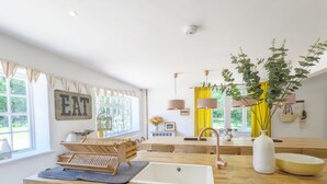 Une cuisine moderne dotée d’un plan de travail en bois, d’un évier et d’un coin repas avec une table et des chaises.