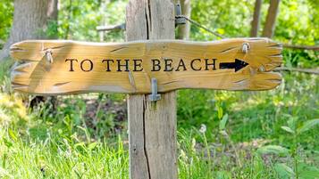 A wooden signpost with the text "TO THE BEACH" and an arrow pointing to the right.