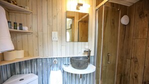 A bathroom with a wooden wall, a stone sink, a glass shower enclosure, and a white toilet. - Knole Luxury Dome (Hoath)