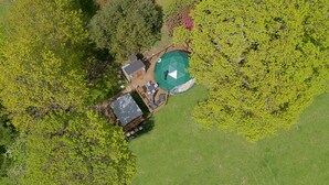 An aerial view of a house with a large deck, surrounded by lush greenery and trees. - Knole Luxury Dome (Hoath)
