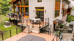 A modern house with a wooden deck, outdoor seating, and a staircase leading to a second floor. - Luxurious Modern Home Steps to Gondola & Village (Stratton)