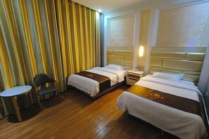 Una habitación de hotel con dos camas, una mesita pequeña y una silla.
