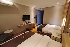 A hotel room with two beds, a small table, a chair, a TV, and a wardrobe. - Jiangcheng Hotel (Rong County)