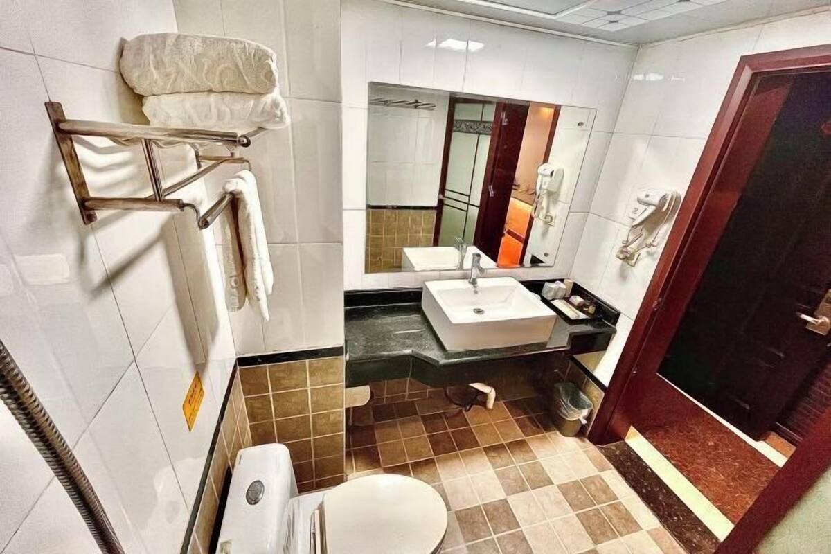 A bathroom with a toilet, sink, and towel rack.