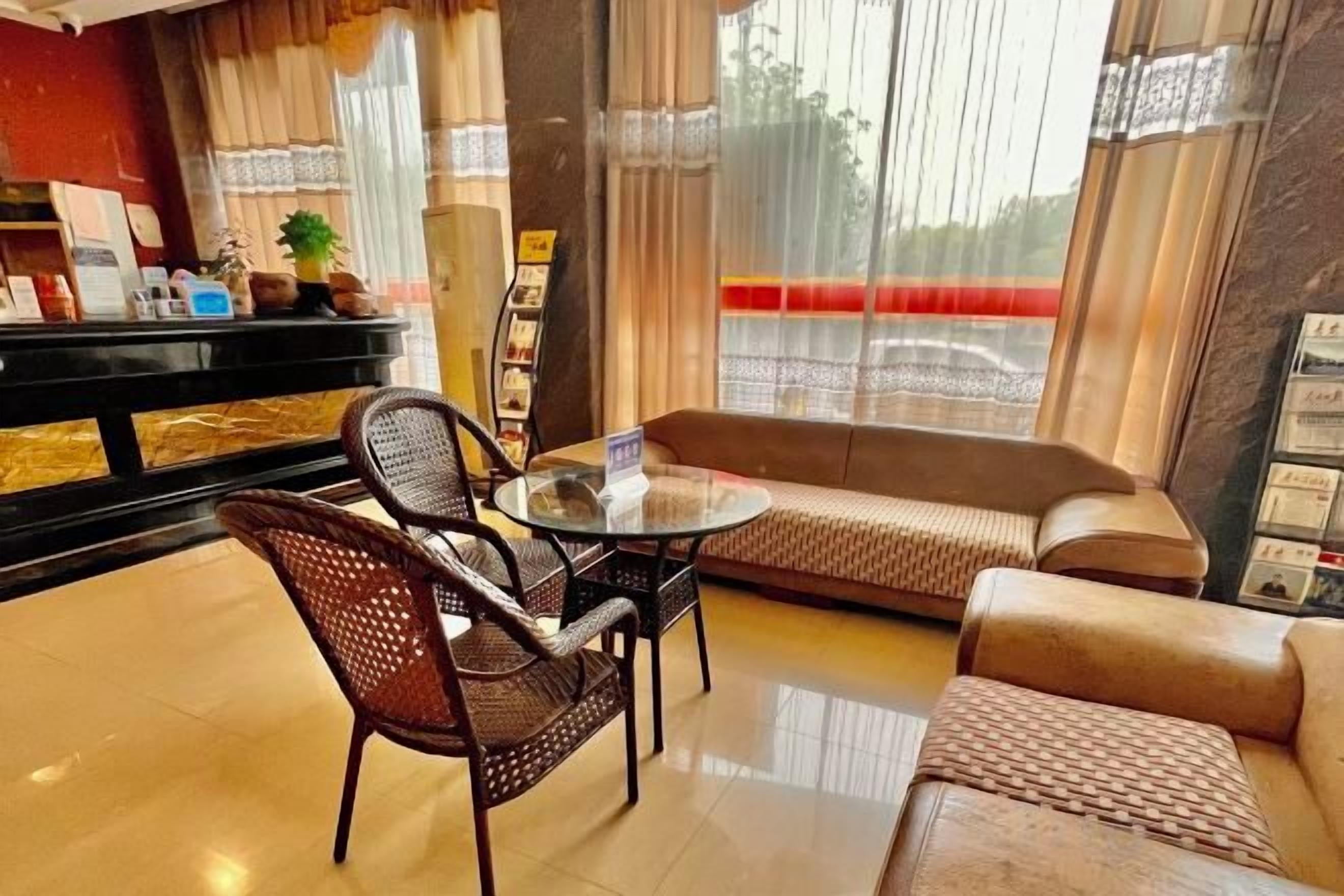 A hotel lobby with a round table, two sofas, and a black piano.