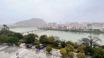 A view of a riverside area with a bridge, buildings, and a parking lot.