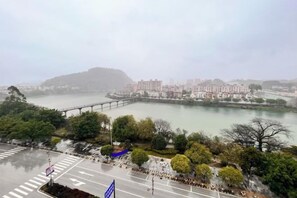 Vista de una zona ribereña con un puente, edificios y un estacionamiento.