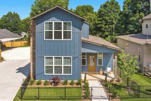 A two-story house with a front porch, a garage, and a well-maintained lawn.