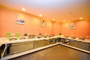A buffet setup with multiple serving stations, a long counter, and a mirrored wall.