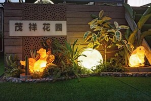 A garden with a sign, illuminated statues, and various plants. - Shenzhen Maoxiang Hotel (Wutongshan Scenic Area) (Shenzhen)