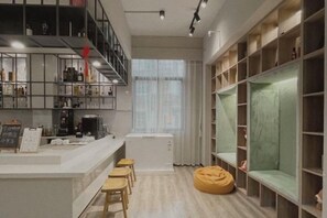 A modern kitchen with a bar area, wooden shelves, and a seating area with a bean bag. - Shenzhen Maoxiang Hotel (Wutongshan Scenic Area) (Shenzhen)
