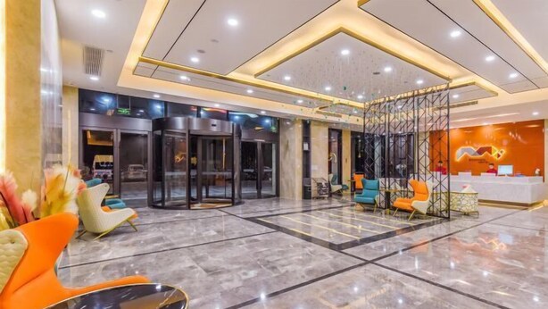 A modern lobby with a marble floor, a reception desk, and a seating area with colorful chairs. - Borrman Hotel (Chongqing Ronghui Peninsula) (Chongqing)