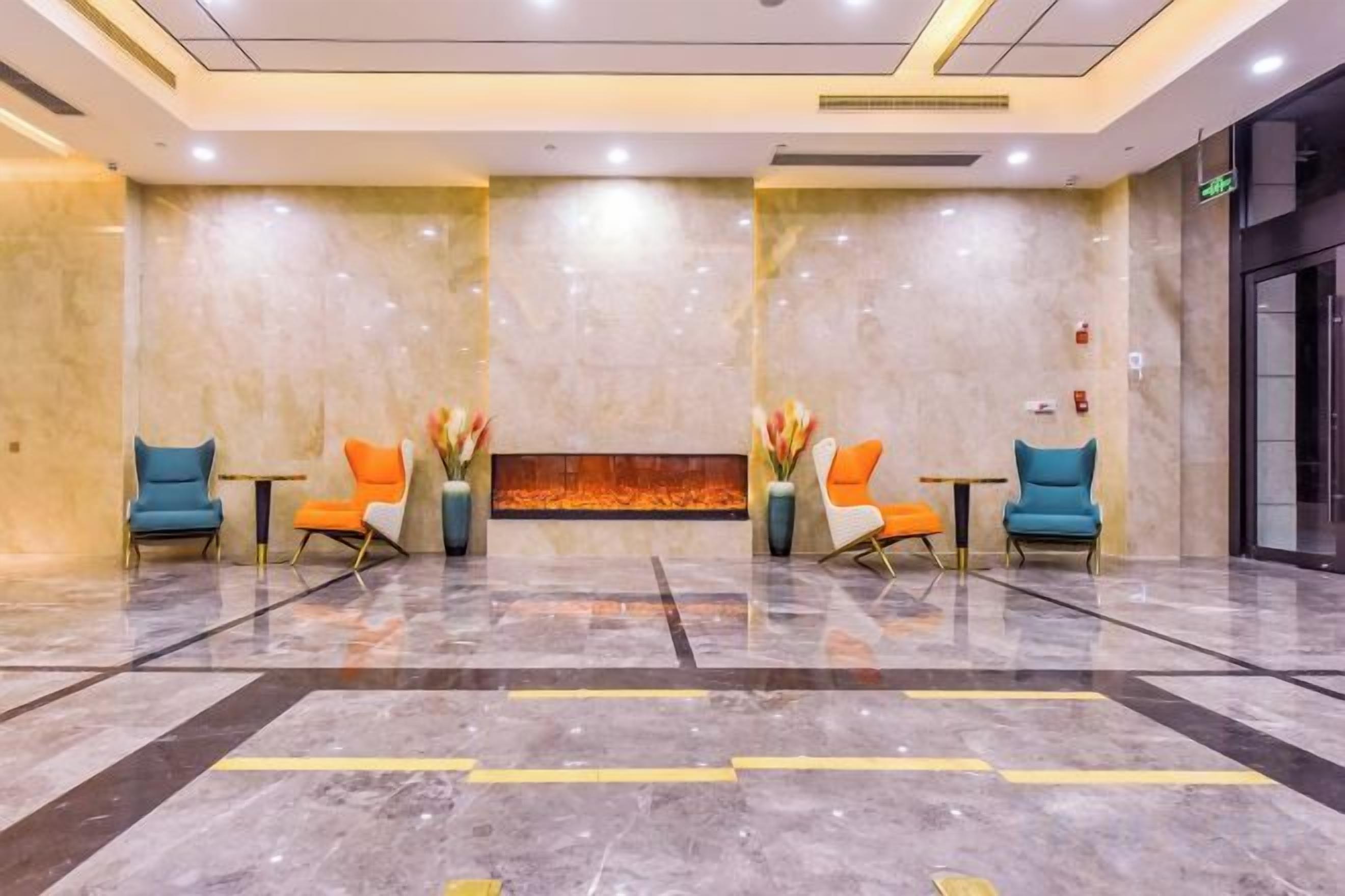 A lobby with a marble floor, two reception desks, and a fire feature.