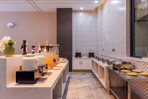 A modern kitchen with a long counter, various appliances, and a patterned backsplash. - Borrman Hotel (Chongqing Ronghui Peninsula) (Chongqing)