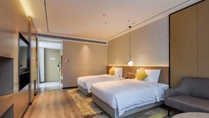 A modern hotel room with two beds, a sofa, a TV, and a hallway leading to another room. - Borrman Hotel (Chongqing Ronghui Peninsula) (Chongqing)