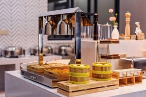 A buffet setup with various food items and a coffee machine. - Borrman Hotel (Chongqing Ronghui Peninsula) (Chongqing)