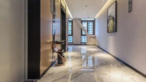 A modern hallway with a polished marble floor, a staircase, and a framed picture on the wall. - Borrman Hotel (Chongqing Ronghui Peninsula) (Chongqing)