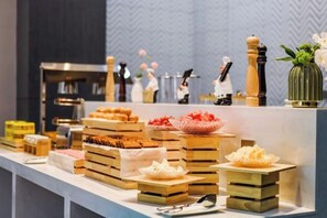A buffet setup with various food items and a kitchen area in the background. - Borrman Hotel (Chongqing Ronghui Peninsula) (Chongqing)