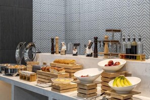 Montaje tipo bufé con diferentes alimentos y utensilios de cocina.