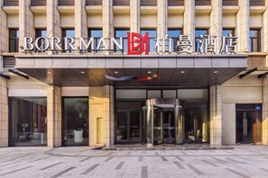A hotel entrance with a modern design, featuring a glass facade and a revolving door. - Borrman Hotel (Chongqing Ronghui Peninsula) (Chongqing)