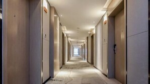 A long, narrow hotel corridor with doors on both sides, leading to individual rooms. - Borrman Hotel (Chongqing Ronghui Peninsula) (Chongqing)