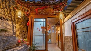 A traditional-style entrance with a wooden door, stone steps, and a small potted plant. - Xijiang Qianhu Miaozhai Hanshe Inn (Observation Deck Store) (Leishan)