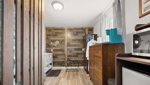 A narrow hallway with wooden flooring, a white dresser, and a mirror on the wall. - Bar Harbor Downtown Suite (Bar Harbor)