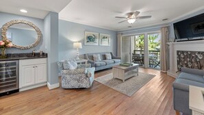 Un salon spacieux comprenant un canapé, des fauteuils, une table basse et une cheminée.