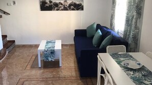 Una sala de estar con un sofá, una mesa de centro y una mesa de comedor.