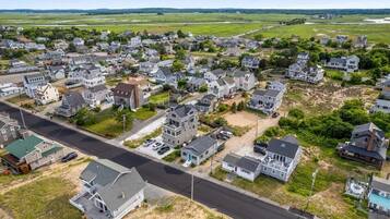 Vue aérienne d’un quartier résidentiel avec des maisons, des routes et des champs ouverts.