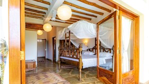 A traditional wooden bed with a canopy, a stone floor, and a small wooden bench. - Luxury Holiday Villa - Private Chef - Pool - A/C (partly) (Ukunda)