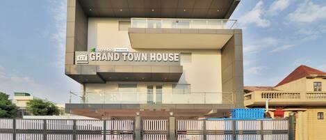 A modern hotel with a prominent sign reading "GRAND TOWN HOUSE".