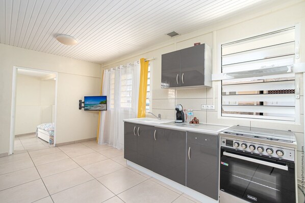 A modern kitchen with a built-in oven, a coffee maker, and a sink.