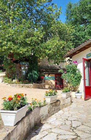 Step into this charming tavern, surrounded by vibrant flowers and lush greenery.