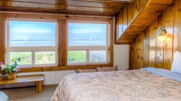 Relax in this inviting bedroom with a large bed, a window offering a view of the outdoors, and a cozy bench.