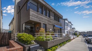 Une maison moderne à deux étages, dotée d’un balcon, d’un garage et d’une allée.