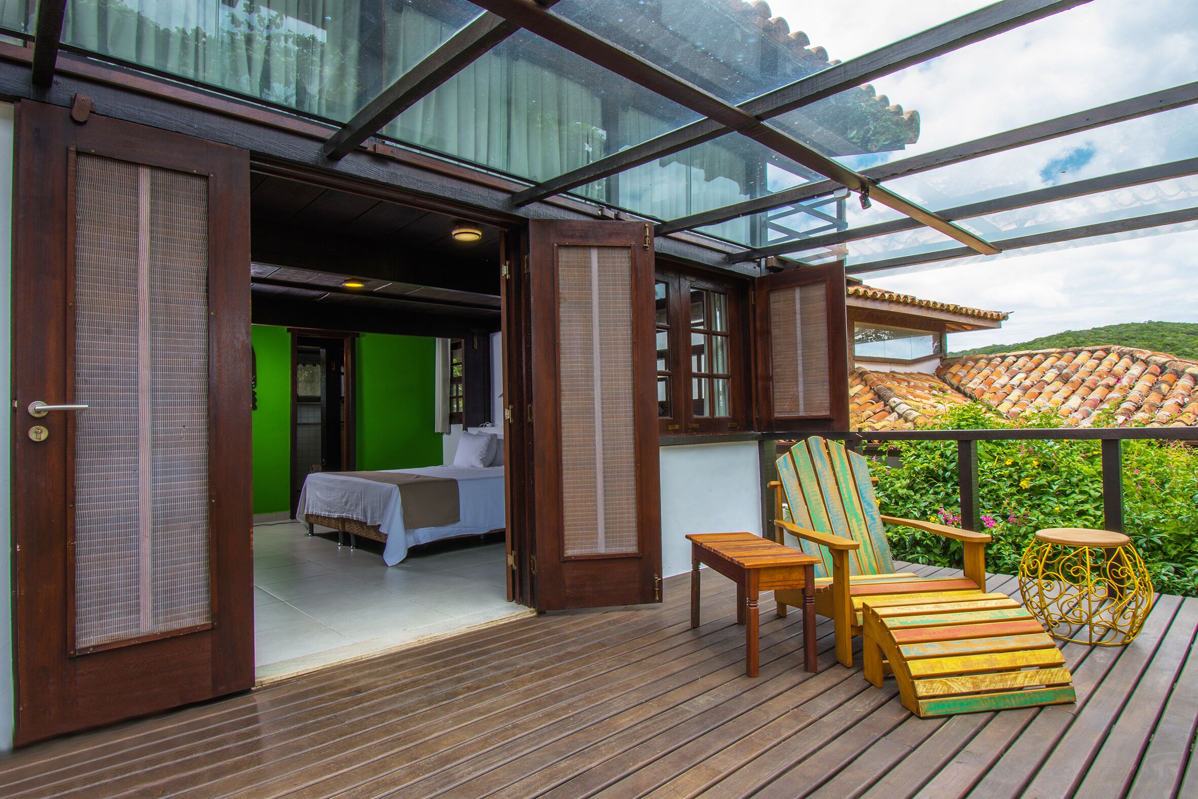 A wooden deck with a bed, a chair, and a small table.