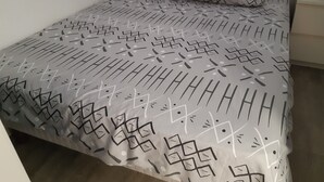 En säng med ett mönstrat överkast och kuddar.