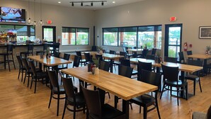 A spacious dining area with multiple tables and chairs, large windows, and a bar counter. - Three-unit SUPER PACKAGE! Sleeps 12. Three linked living, kitchen, and bedrooms. (Branson)