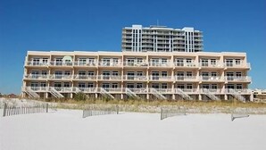 Een meerlaags hotel met balkons en uitzicht op het strand.
