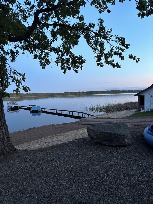 A lakeside dock with boats, a small building, and a large rock. - Quiet retreat on Little Whitefish Lake (Garrison)