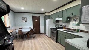A kitchen with a dining table, chairs, a stove, and cabinets. - Quiet retreat on Little Whitefish Lake (Garrison)