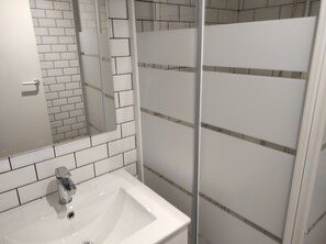 Een douche, handdoeken, zeep, toiletpapier