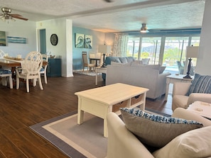 A spacious living room with a dining area, a sofa set, and a ceiling fan. - Beautiful canal view, direct Gulf access, gorgeous heated pool! (Cape Coral)