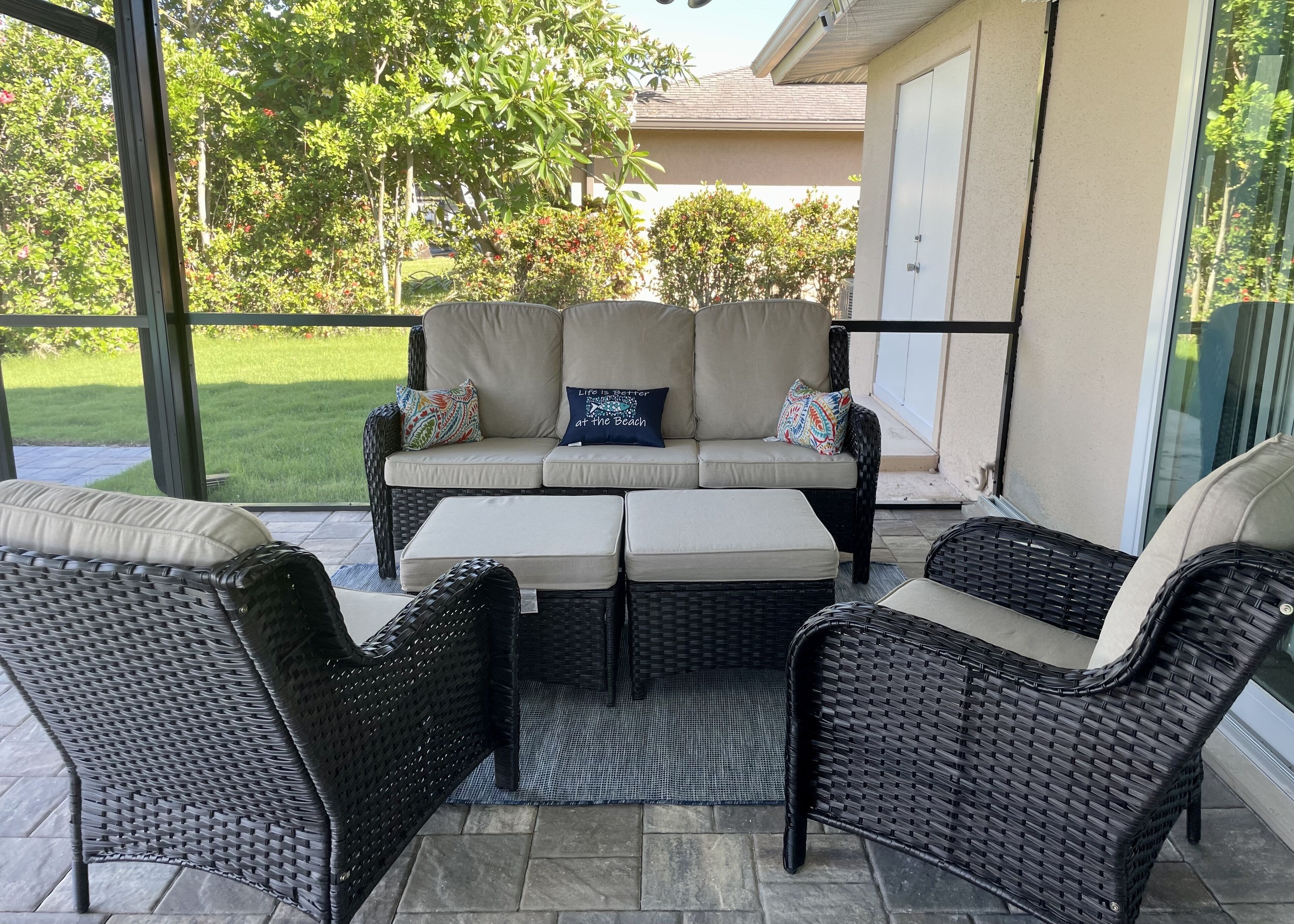An outdoor patio area with a sofa set, two armchairs, and a small table.