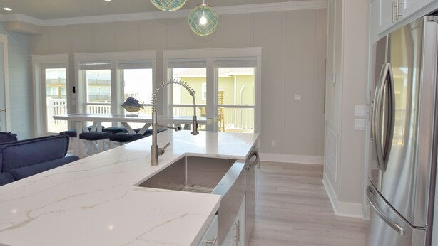 A spacious kitchen with a large island, stainless steel appliances, and pendant lighting.