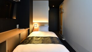 A hotel room with a bed, bedside table, lamp, and a mirror. - FL Hotel Asakusa (Tokyo)