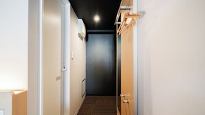 A narrow hallway with a patterned carpet, a door at the end, and a light fixture on the ceiling. - FL Hotel Asakusa (Tokyo)